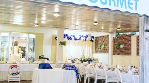 um salão de banquetes com mesas brancas e cadeiras brancas em Petit gourmet em Siderno Marina