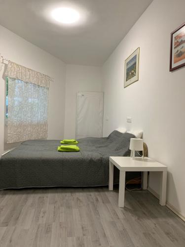 a bedroom with a bed and a white table at Levendulakert Siófok Apartmanház in Siófok