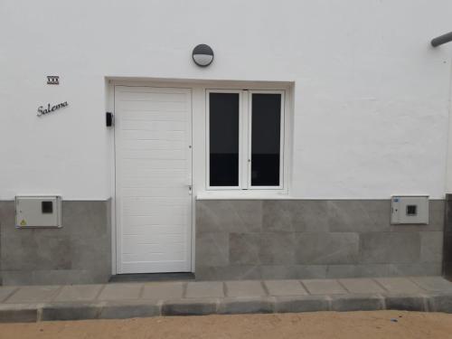 un edificio blanco con puerta y ventana en SALEMA, en Caleta de Sebo