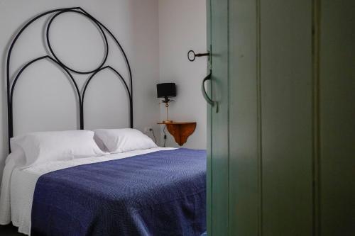a bedroom with a large bed with a blue blanket at Hospederia Santa Clara in Utrera