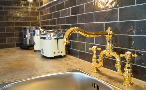 a kitchen sink with a gold faucet on a counter at Premium Residences Rauris incl Sommercard in Rauris