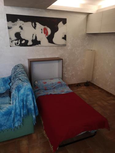 una piccola camera con un letto e un dipinto sul muro di B&B Monte Marano a Latina