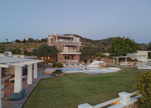 a house with a yard with a swimming pool at Villa Tzikides Aegina in Tzíkidhes