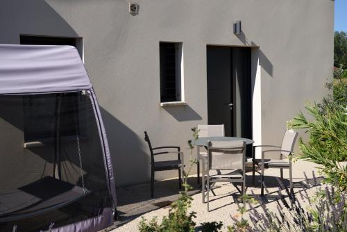 a patio with a table and chairs and a building at Gite Les Lavandes in Vaison-la-Romaine