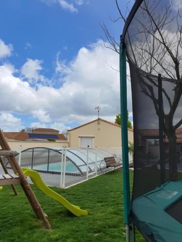 un parque infantil con un tobogán en un patio en Chez les J-FOLAIS - 3 kms Puy duFou - Les Epesses en Les Épesses