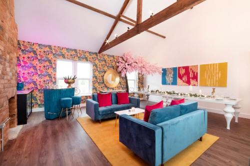 a living room with blue couches and red pillows at Innvigour Bespoke House with Free Parking for 3 Cars in York