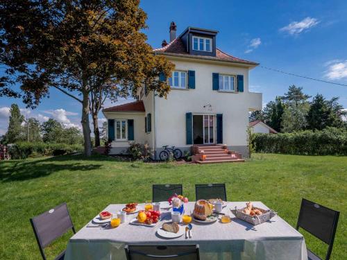 une table avec de la nourriture devant une maison dans l'établissement Gîte Les Volets Bleus, à Bœrsch
