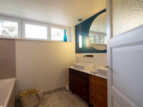 ein Badezimmer mit zwei Waschbecken, einer Badewanne und einem Spiegel in der Unterkunft Gîte Les Volets Bleus in Boersch