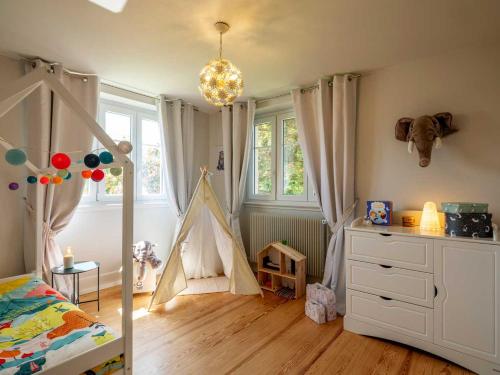 a bedroom with a bed and a play tent at Gîte Les Volets Bleus in Boersch