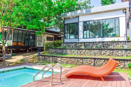 a bench next to a house with a swimming pool at OYO Capital O 390 Nana River Kaeng Krachan in Kaeng Krachan