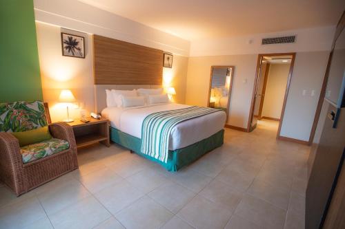 a hotel room with a bed and a chair at Vidam Hotel Aracaju - Transamerica Collection in Aracaju