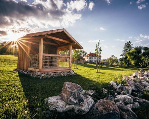 a gazebo in a field with rocks at Aparthotel & Wellness Knížecí cesta in Horní Planá