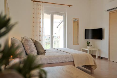 a bedroom with a bed and a tv and a window at KARBONACA APARTMENTS in Fažana
