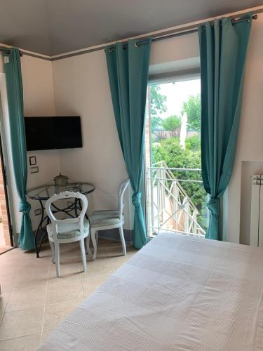 a bedroom with a bed and a table and a window at Relais Il Margarito in Montefano