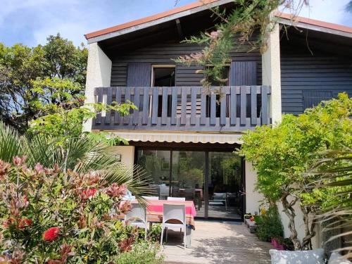 Cette maison dispose d'un balcon avec une table et des chaises. dans l'établissement La Patio Butia, à Seignosse