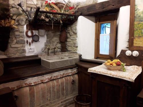 una cocina con fregadero y un bol de fruta en una barra en Mulino Sandaci - Casa Vacanze en Montefotogno