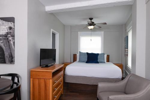 a bedroom with a bed and a tv and a chair at Club Wyndham Riverside Suites in San Antonio
