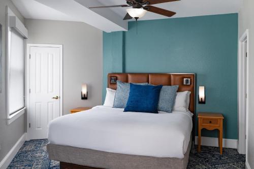 a bedroom with a bed and a blue wall at Club Wyndham Riverside Suites in San Antonio