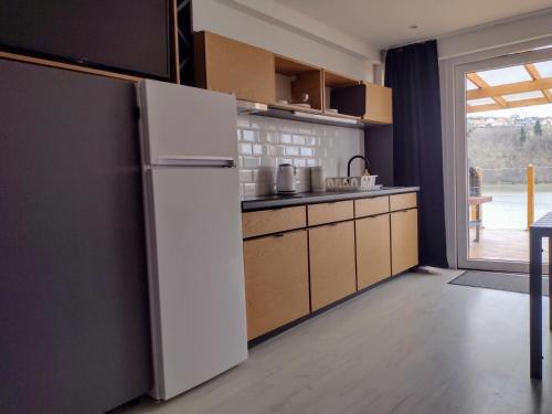 a kitchen with a white refrigerator and a window at Villa Solina in Zawóz