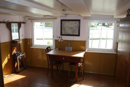 TengenにあるFerienwohnung Finkの木製テーブルと窓2つが備わる客室です。