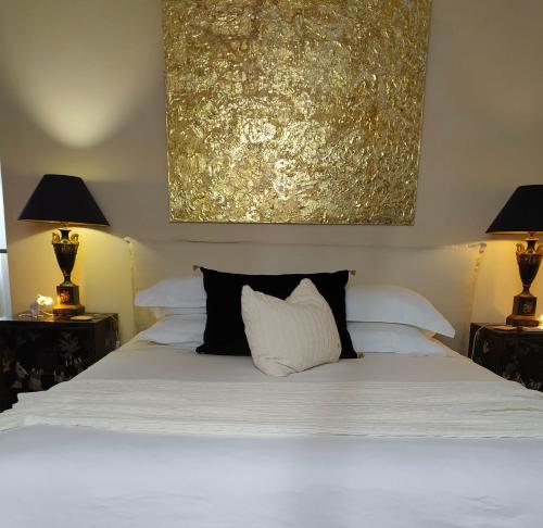 ein Schlafzimmer mit einem weißen Bett mit zwei Lampen in der Unterkunft Suite dans Une Echoppe in Bègles
