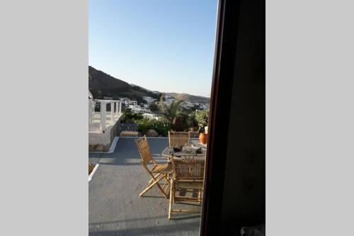 a table and chairs on the roof of a house at Sunset Apartment in Patmos