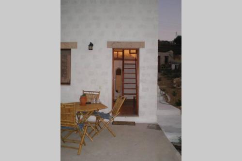 a patio with a table and chairs in front of a door at Sunset Apartment in Patmos