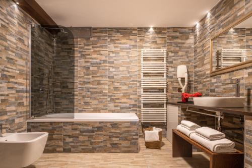 Centrale Venice Apartments في البندقية: حمام مع حوض ومغسلة وحوض استحمام