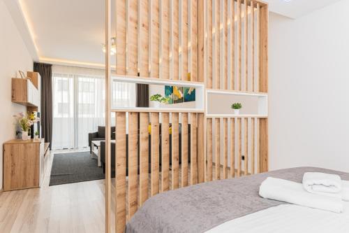 a bedroom with a wooden wall with a bed at Isaran 2D3E Apartment Brașov in Braşov