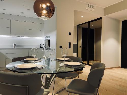 comedor con mesa de cristal y sillas en Dream Stay - Executive Apartment with Balcony, en Tallin