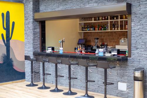 a bar with stools in front of a brick wall at Silver Moon Hotel in Abidjan