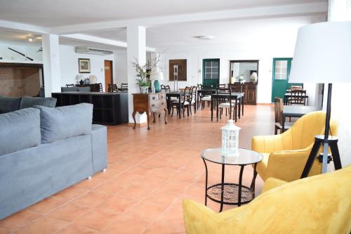 a living room with a couch and tables and chairs at Quinta da Nave do Lobo in Marvão