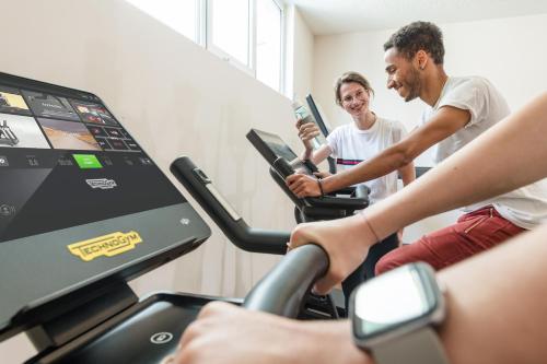 a group of people on a treadmill in a gym at Hotel Norica - Thermenhotels Gastein mit dem Bademantel direkt in die Therme in Bad Hofgastein