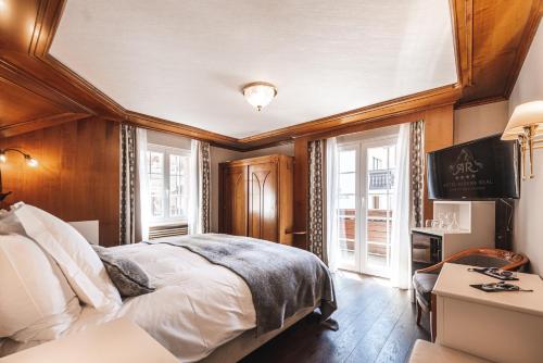 Un dormitorio con una cama grande y una ventana en Boutique Hotel Albana Real - Restaurants & Spa en Zermatt
