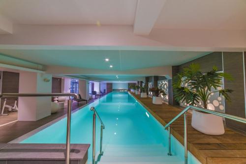 une piscine dans un hôtel avec un bâtiment dans l'établissement Les Jardins de St Cloud, à Saint-Cloud