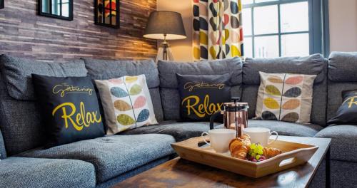 a living room with a couch and a table with a tray of food at 2 The Gathering Chester Central in Chester
