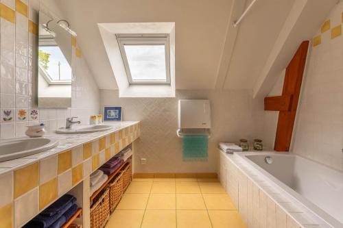 ein Badezimmer mit einer Badewanne und einem Waschbecken in der Unterkunft La Maitrie in Plouër-sur-Rance