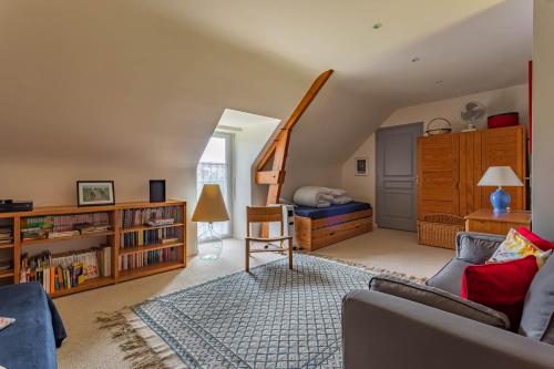ein Wohnzimmer mit einem Sofa und einem Bett in der Unterkunft La Maitrie in Plouër-sur-Rance