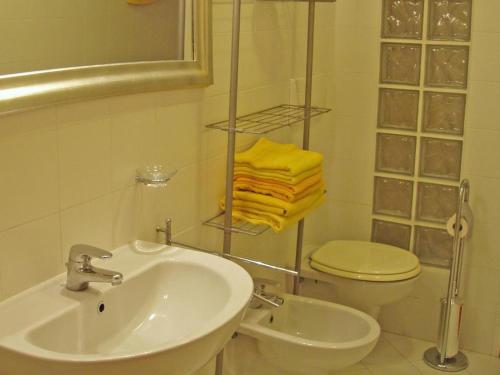 ein Bad mit einem Waschbecken, einem WC und Handtüchern in der Unterkunft Trebbiano in Gravedona