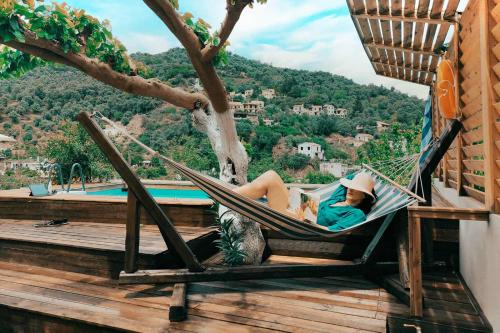 a woman laying in a hammock by a pool at Villa Roxani in Mesklá