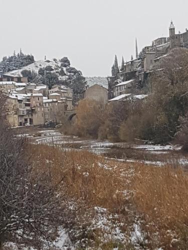 a city with buildings and a river with snow at Gite Les Lavandes in Vaison-la-Romaine