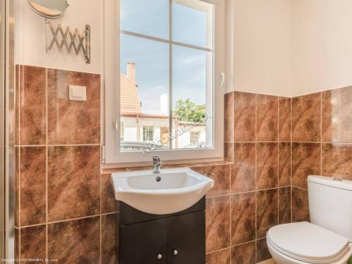 ウストカにあるApartamenty Blisko Morzaのバスルーム(洗面台、トイレ付)、窓が備わります。