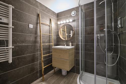 une salle de bain avec un lavabo, une douche et un miroir dans l'établissement Marius - studio au cœur de la bastide, à Carcassonne