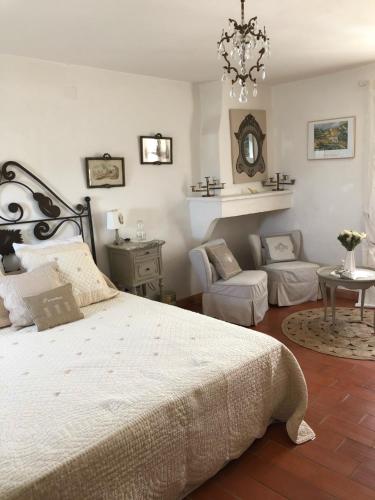 une chambre avec un grand lit et un lustre dans l'établissement Maison de village en Provence, à Baudinard