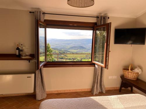 a bedroom with a bed and a window at Vitabella Toscana in Seggiano
