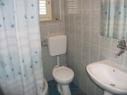 łazienka z toaletą i umywalką w obiekcie House Lumbarda (876) w mieście Lumbarda
