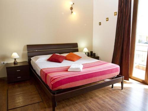 een slaapkamer met een bed met 2 kussens erop bij Cuscino e Cappuccino B&B in Alghero