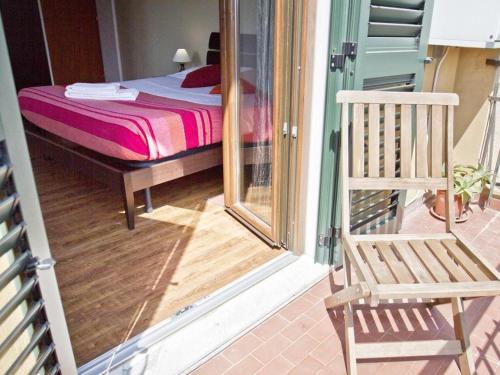 een slaapkamer met een bed en een stoel op een veranda bij Cuscino e Cappuccino B&B in Alghero
