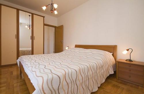 a bedroom with a bed and a lamp and a dresser at Holiday Home in Betina with Seaview, Terrace, Air condition, WIFI (4671-1) in Betina