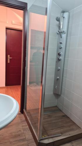a bathroom with a glass shower door and a sink at Apartmani Mašić Trebinje in Trebinje